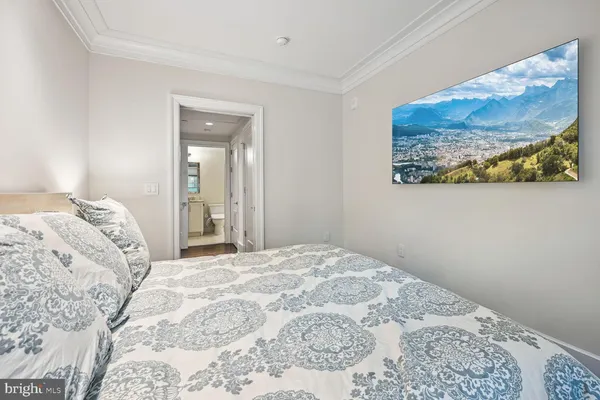 a bedroom with a bed and painting on the wall