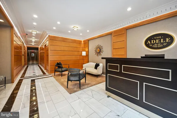 a view of a hallway with wooden floor and furniture