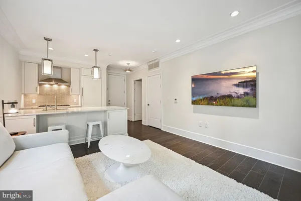 a large white kitchen with a white countertops a stove a dining table and chairs