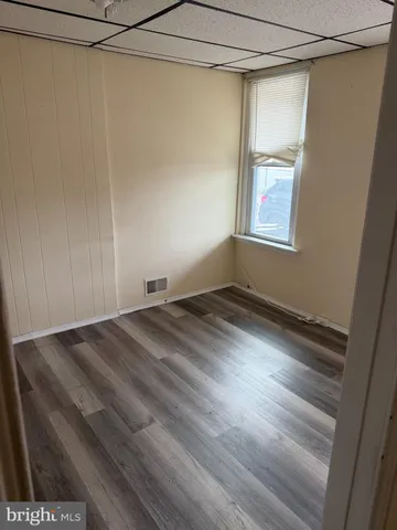 a view of a room with wooden floor and front door