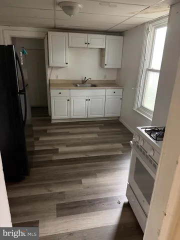 a kitchen with granite countertop white cabinets and stainless steel appliances