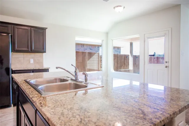 a kitchen with granite countertop a sink and a stove