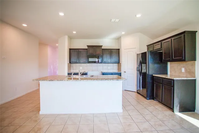 a large kitchen with stainless steel appliances granite countertop a large counter top and a stove top oven