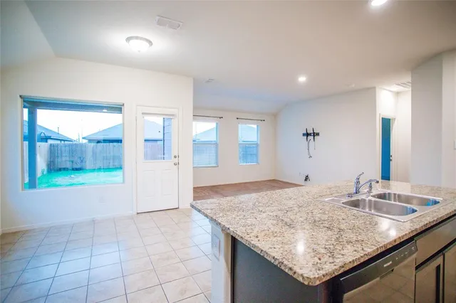 a kitchen with granite countertop sink and window