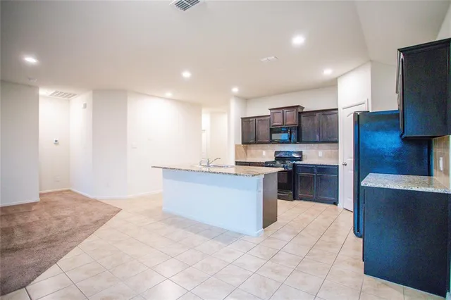 a large kitchen with stainless steel appliances cabinets a sink and a stove