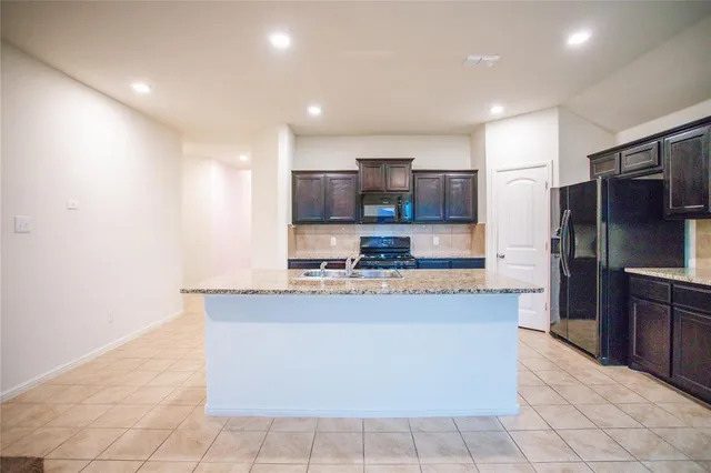 a large kitchen with stainless steel appliances a refrigerator and a stove