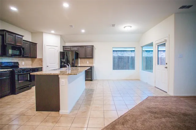 a large kitchen with a large counter top appliances and cabinets