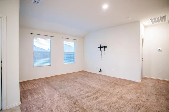 an empty room with a windows and a ceiling fan