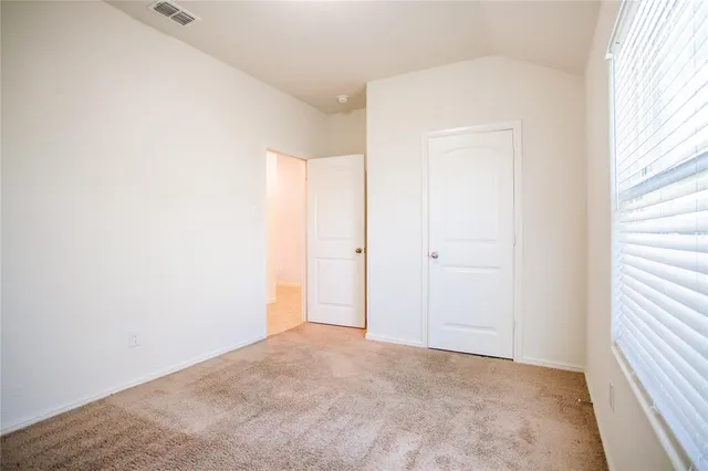 an empty room with windows and closet
