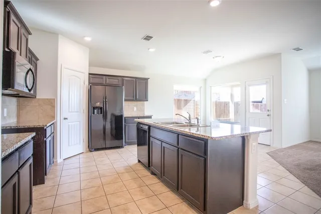 a kitchen with stainless steel appliances granite countertop a refrigerator and a stove top oven
