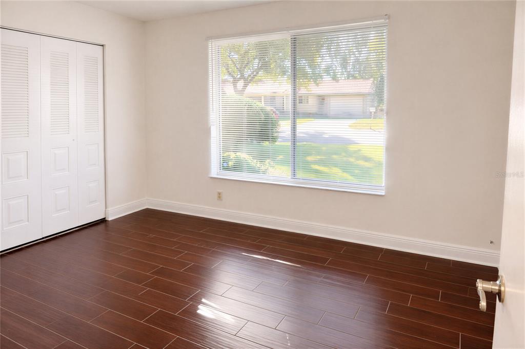 10849 Wheaton Court Orlando, FL 32821 - Photo 12 of 16 a view of an empty room with wooden floor and a window