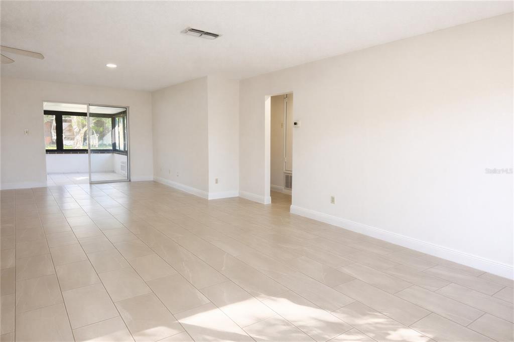 10849 Wheaton Court Orlando, FL 32821 - Photo 9 of 16 a view of an empty room with window and wooden floor