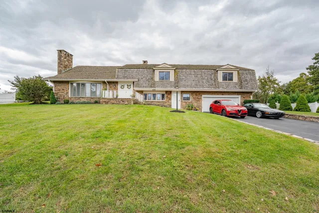 a front view of house with yard and garage