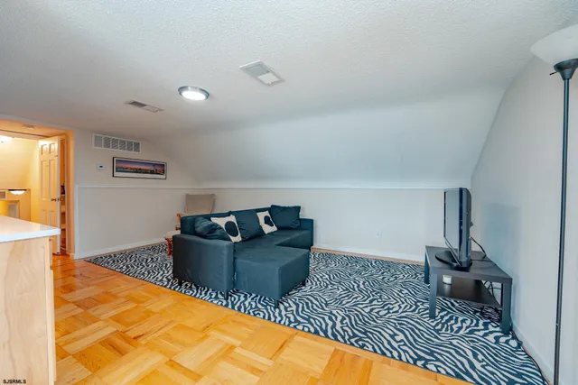 a spacious bedroom with a bed and wooden floor