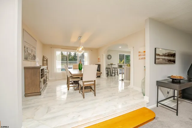 a living room with stainless steel appliances kitchen island granite countertop furniture and a view of kitchen