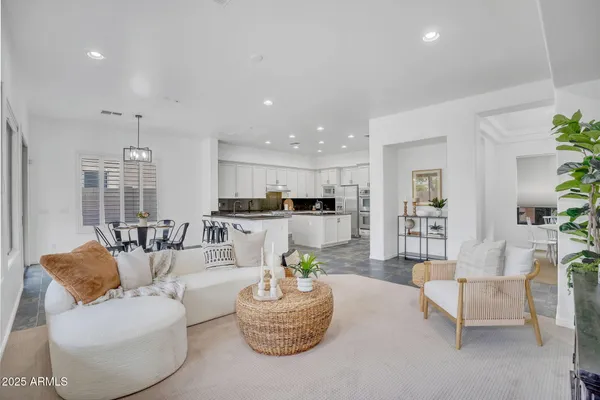 a living room with furniture kitchen and a potted plant