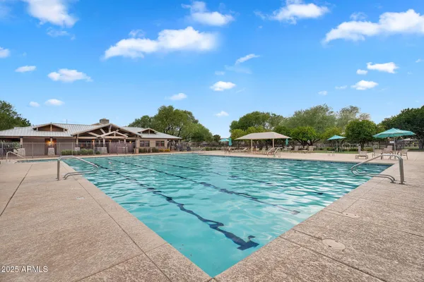 a view of a swimming pool with a patio and a yard