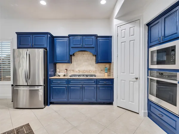 a kitchen with granite countertop a refrigerator and a stove top oven
