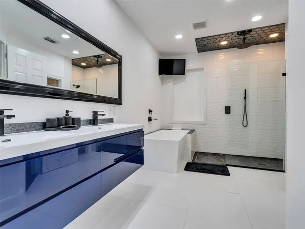 a bathroom with a double vanity sink toilet mirror and bathtub