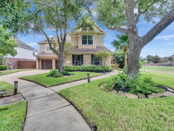 a front view of a house with a yard and potted plants