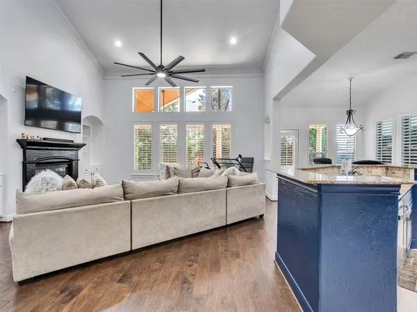 a living room with couches a flat screen tv and kitchen view