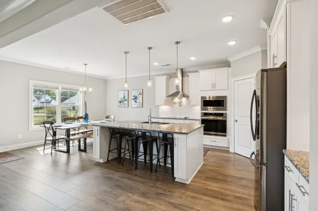a kitchen with stainless steel appliances granite countertop a refrigerator and a sink