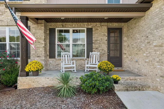 a front view of a house with outdoor seating and a garden