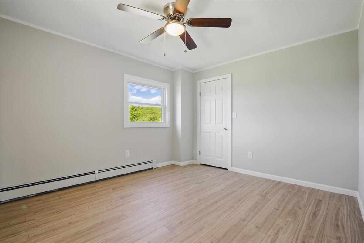 1652 Bonser Road Saylorsburg, PA 18353 - Photo 22 of 62 an empty room with wooden floor ceiling fan and windows