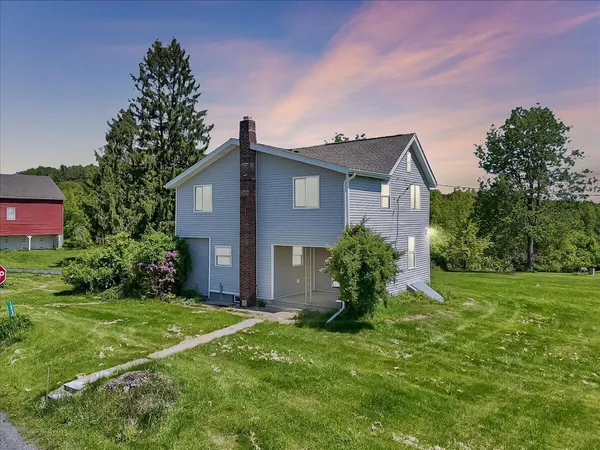 an aerial view of a house with a garden and lake view