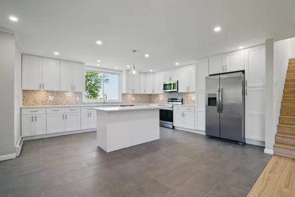 a kitchen with stainless steel appliances granite countertop a sink and cabinets