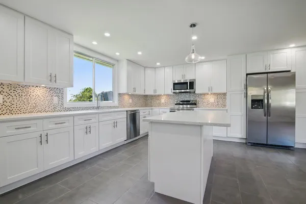 a kitchen with a sink window and cabinets