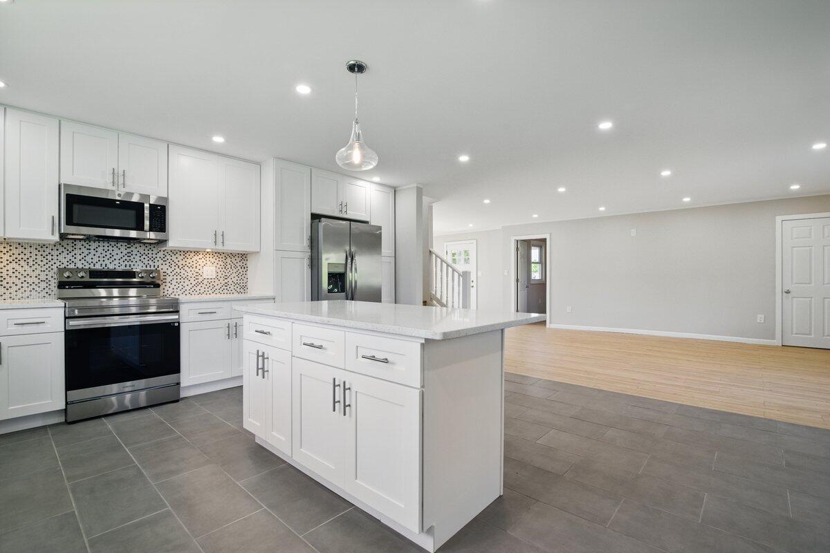 1652 Bonser Road Saylorsburg, PA 18353 - Photo 10 of 62 a kitchen with stainless steel appliances kitchen island granite countertop a stove top oven a sink and a refrigerator