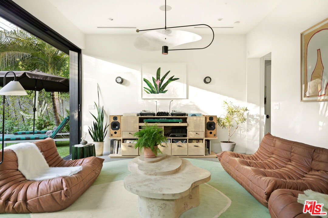 a living room with patio furniture and a floor to ceiling window
