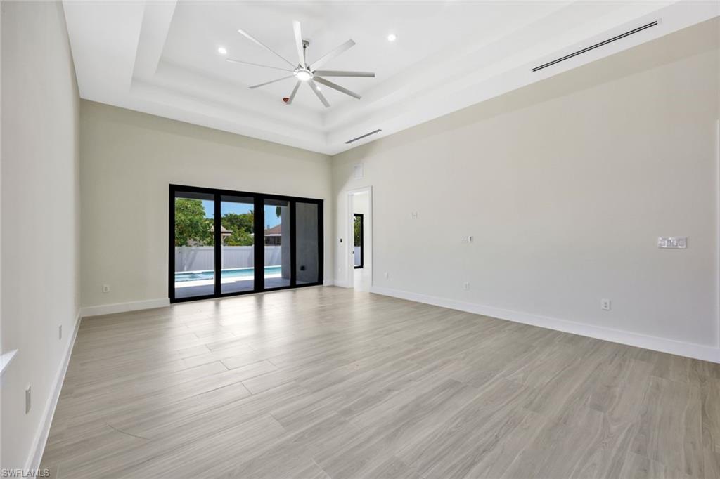 1297 Trail Terrace Drive Naples, FL 34103 - Photo 12 of 29 an empty room with wooden floor and a ceiling fan