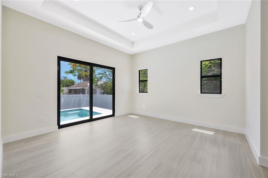 1297 Trail Terrace Drive Naples, FL 34103 - Photo 14 of 29 an empty room with wooden floor and windows
