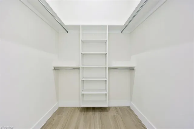 a view of walk in closet with empty racks