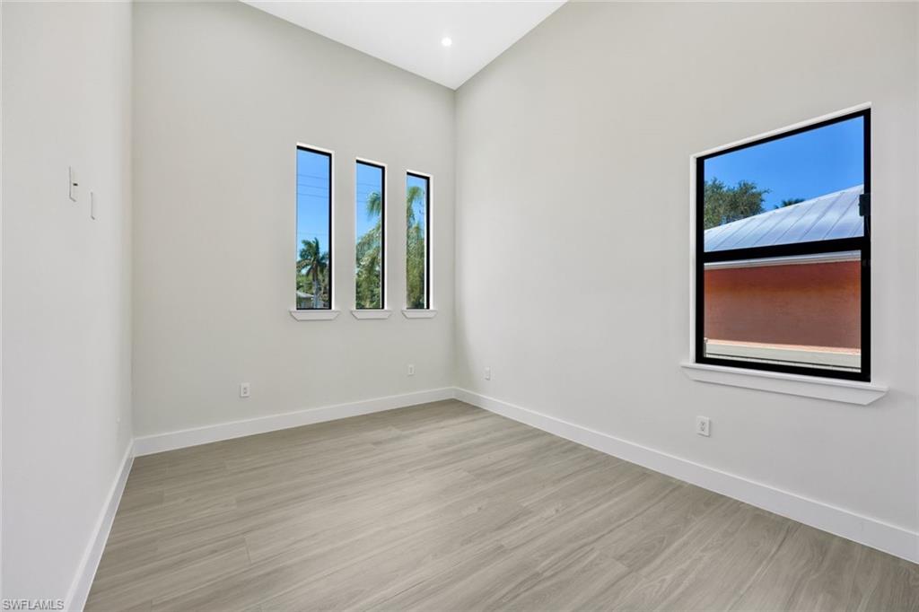 1297 Trail Terrace Drive Naples, FL 34103 - Photo 20 of 29 a view of an empty room with wooden floor and a window