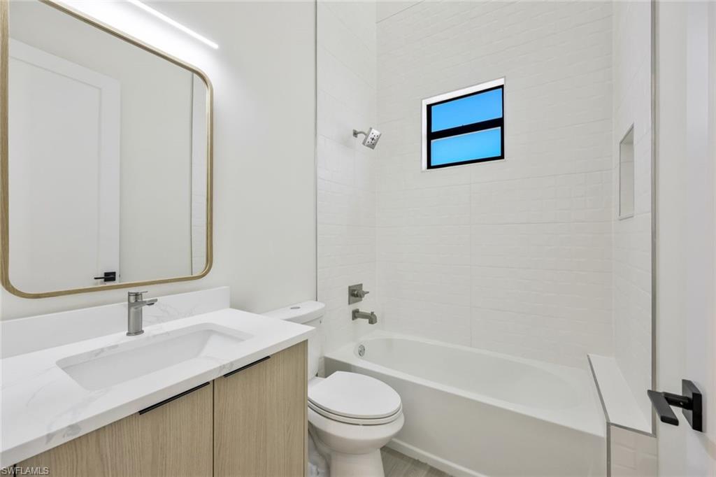 1297 Trail Terrace Drive Naples, FL 34103 - Photo 21 of 29 a bathroom with a granite countertop sink toilet and a mirror