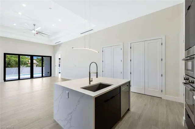 a kitchen with granite countertop a sink and dishwasher with wooden floor