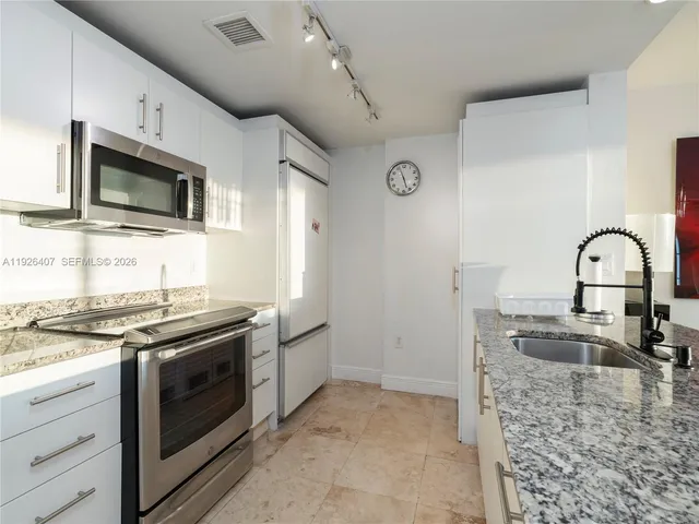 a kitchen with stainless steel appliances granite countertop a stove and a microwave