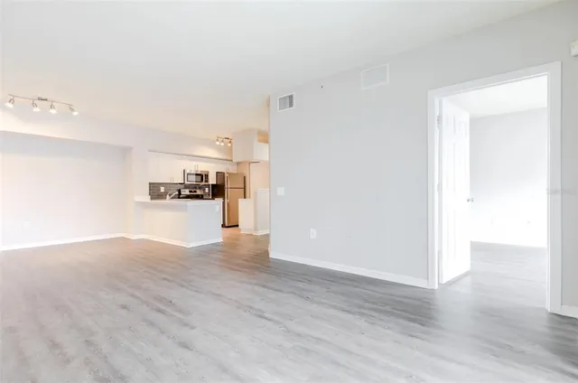 a view of a kitchen with wooden floor and a refrigerator