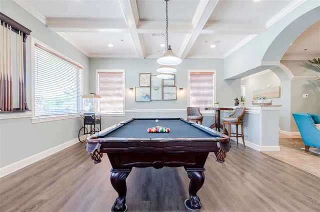 a room with furniture pool table and windows