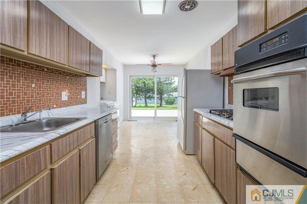 15 Pelham Road Kendall Park, NJ 08824 - Photo 17 of 26 a kitchen with a sink stove and cabinets