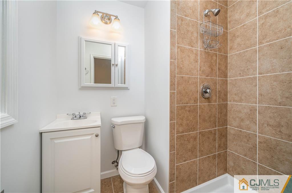 15 Pelham Road Kendall Park, NJ 08824 - Photo 25 of 26 a bathroom with a toilet sink vanity and mirror