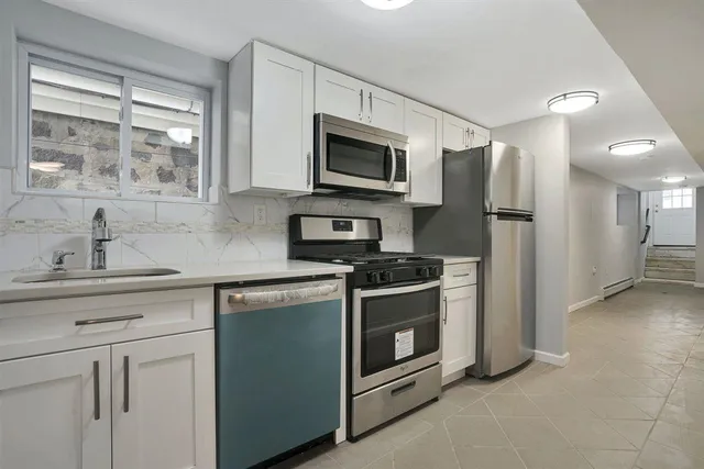a kitchen with stainless steel appliances a stove a sink and a microwave