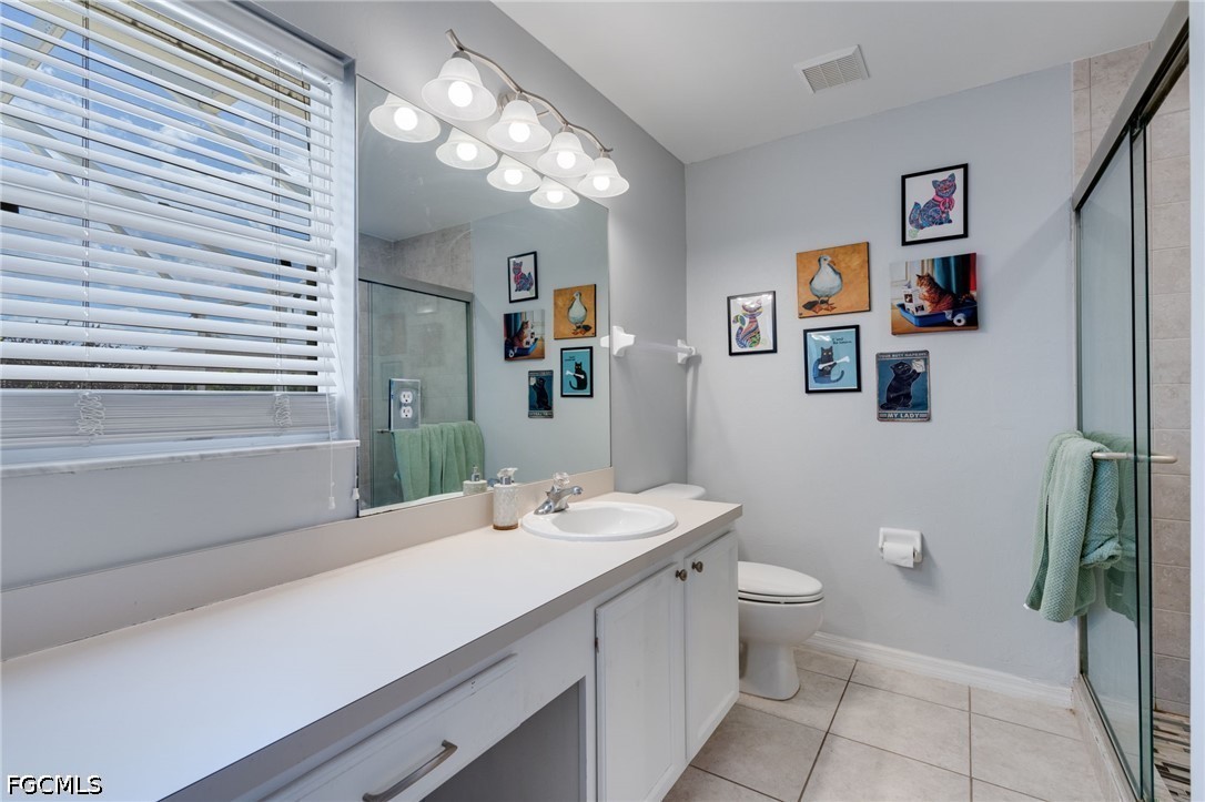 3801 28th Street Southwest Lehigh Acres, FL 33976 - Photo 19 of 37 a bathroom with a sink a toilet a mirror and shower