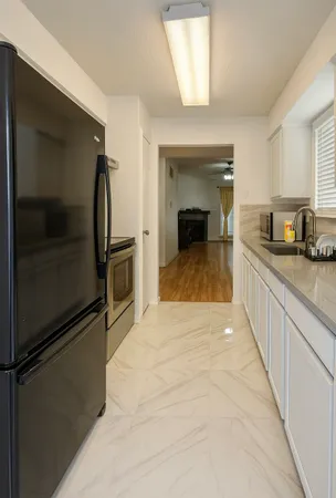 a kitchen with granite countertop a refrigerator and a sink
