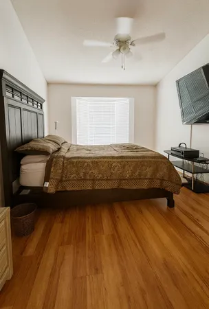 a bedroom with a bed and wooden floor