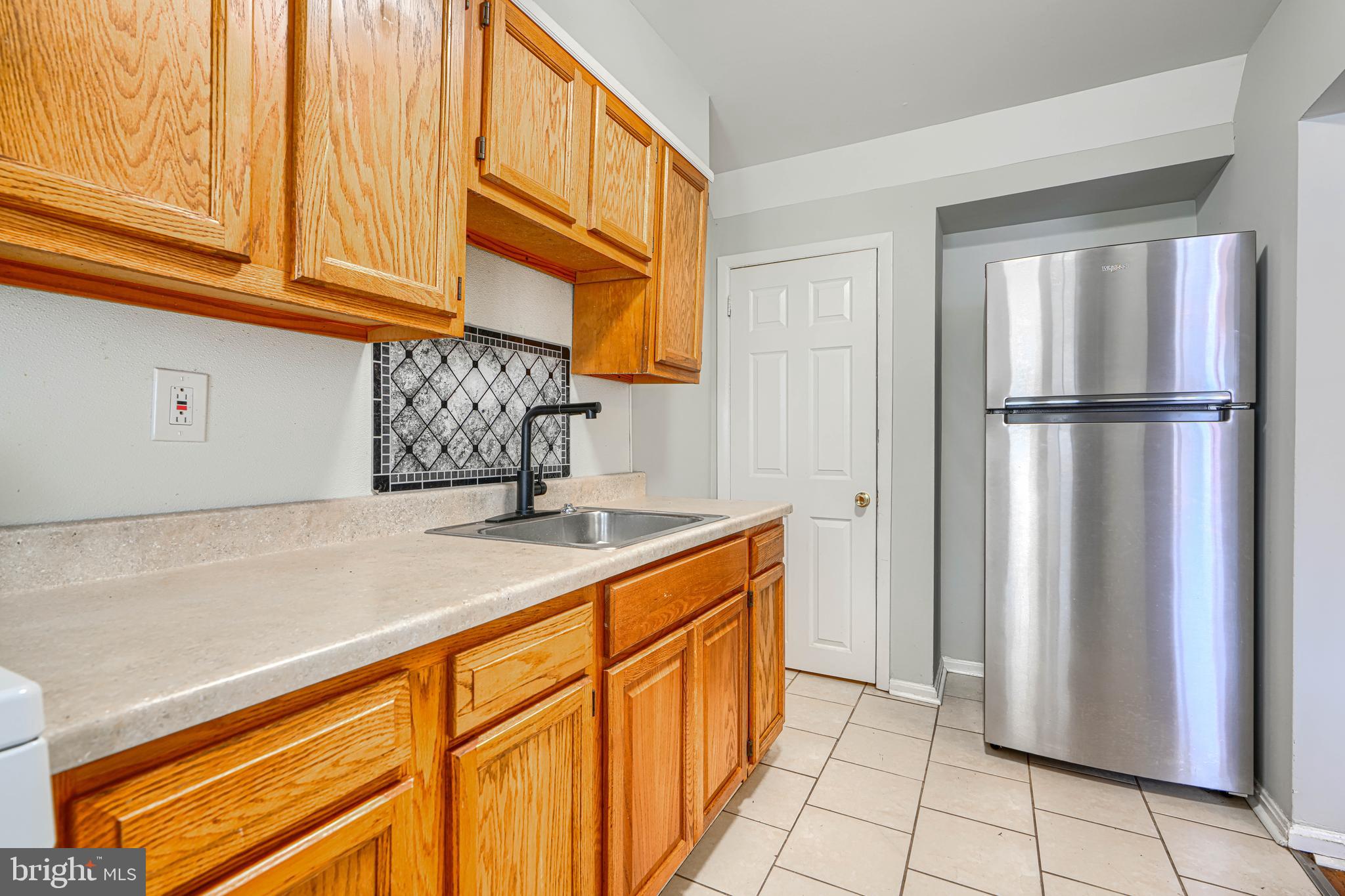 2073 Jasmine Road Baltimore, MD 21222 - Photo 11 of 29 a kitchen with a refrigerator and a sink