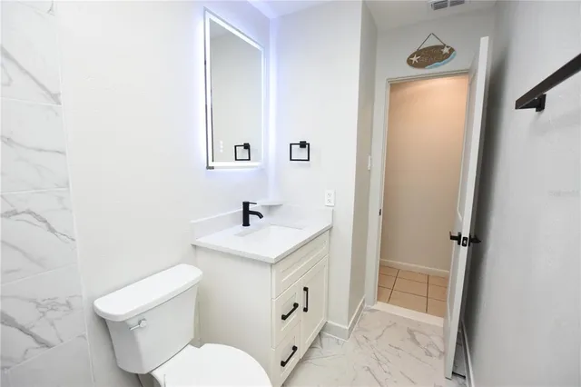 a white toilet sitting next to a bathroom sink